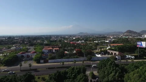 Aerial view of the road between trees and hills in the background Stock Footage 234535226