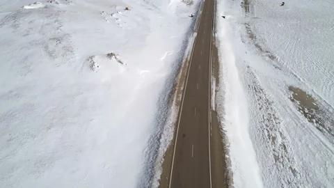 Aerial view on a road between the white snowy hills. Beautiful winer landscape Stock Footage 154131540