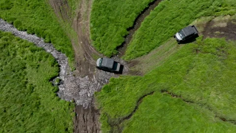 Aerial view of off-road buggies driving through scenic green mountains Stock Footage 341095754