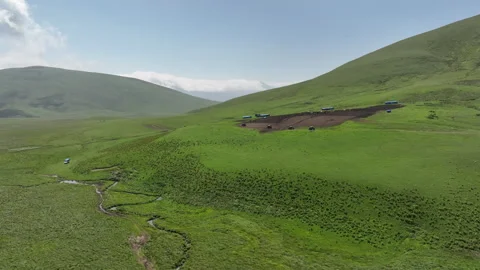 Aerial view of off-road buggies driving through scenic green mountains Stock Footage 341096583