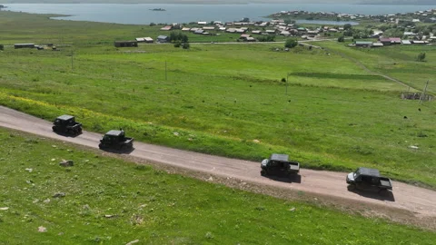 Aerial view of off-road buggies driving through scenic green mountains Stock Footage 341101257
