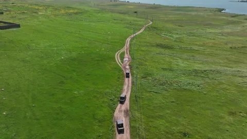 Aerial view of off-road buggies driving through scenic green mountains Stock Footage 341101896