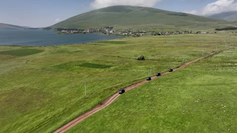 Aerial view of off-road buggies driving through scenic green mountains Stock Footage 341102158