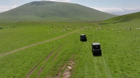 Aerial view of off-road buggies driving through scenic green mountains Stock Footage 341103662