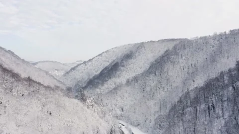 Aerial view of road crossing between mountains covered by snow, Zumberak. Video stock 147925992