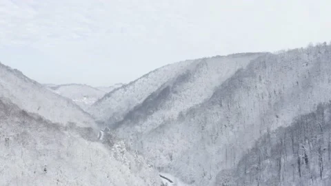 Aerial view of road crossing between mountains covered by snow, Zumberak. Stock Footage 151232843