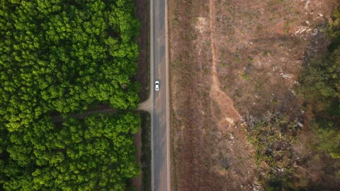 Aerial view of a road that cuts through forest and area destroyed by humans. Stock Footage 234282779