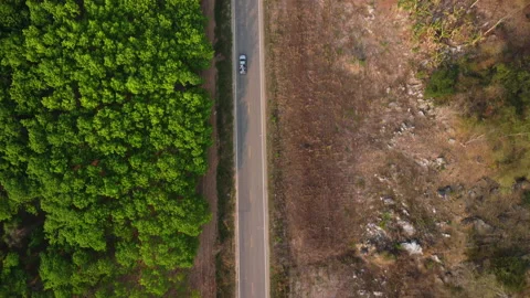 Aerial view of a road that cuts through forest and area destroyed by humans. Stock Footage 234283614