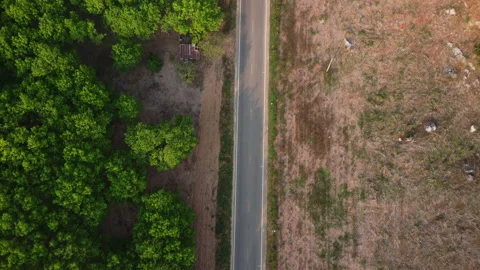 Aerial view of a road that cuts through forest and area destroyed by humans. Stock Footage 234287312