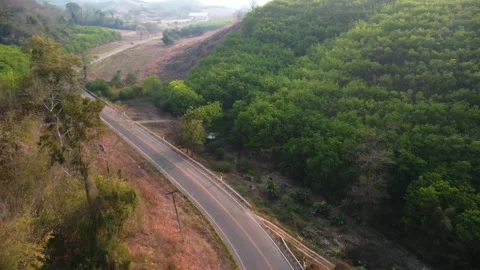 Aerial view of a road that cuts through forest and area destroyed by humans. Stock Footage 234316276