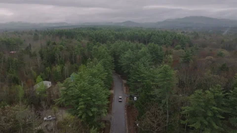 Aerial view of a road cutting through the New Hampshire wilderness Stock Footage 308488355