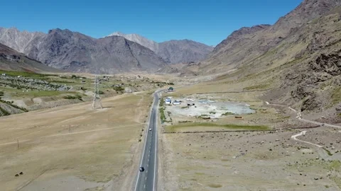 Aerial View of a Road Cutting Through a Vast Valley with Snow-Capped Mounta.. Stock Footage 345731607