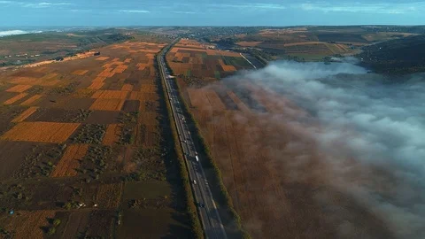 Aerial view of a road in fog and surrounded by fields. Stock Footage