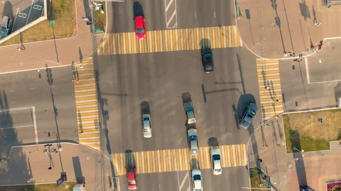 Aerial view of road junction with moving cars and people crossing the road Stock Footage 104932186