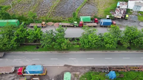 Aerial view of a road lined with trucks parked on the side of the road in a.. Stock Footage 297460182
