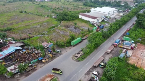 Aerial view of a road lined with trucks parked on the side of the road in a.. Stock Footage 297460201