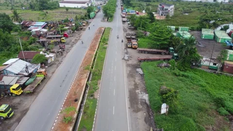 Aerial view of a road lined with trucks parked on the side of the road in a.. Stock Footage 297461179