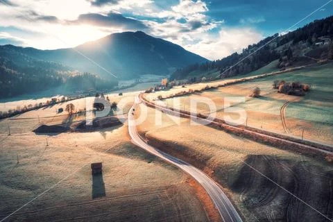 Aerial view of the road in mountain valley at sunset Stock Photos