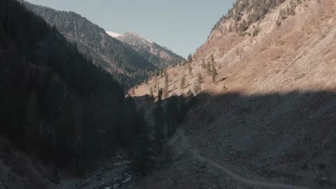 Aerial view of a road in the mountains with trees and river Stock Footage 172397916