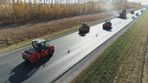 Aerial view. Road rollers level the fresh asphalt. Loading the asphalt mixture Stock Footage 138537791