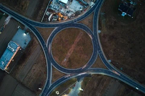 Aerial view of road roundabout intersection with fast moving heavy traffic at Foto stock