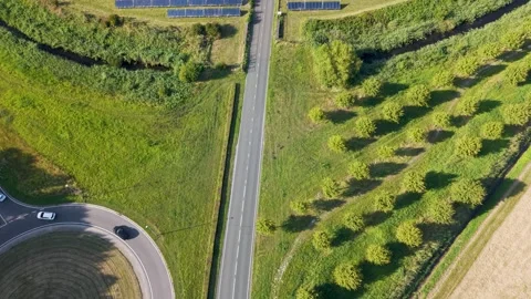 Aerial view of road through vast solar farm producing clean renewable energy Stock Footage 314667553
