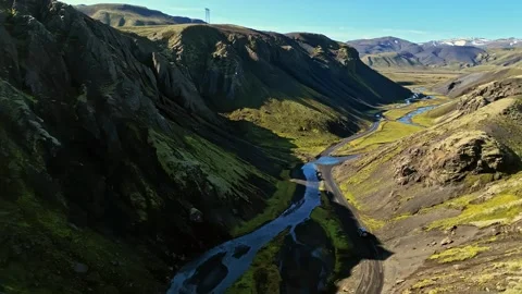 Aerial view of off-road vehicles navigating a narrow river valley between Stock Footage 333641754