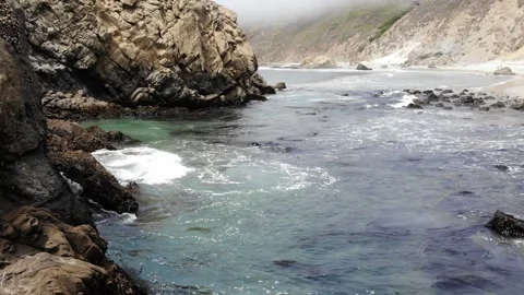 Aerial View of Rock Formations in Ocean with Waves in Slow Motion Stock Footage 142306843