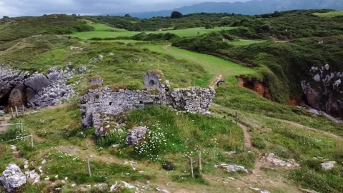 Aerial View of rocky coastline with cliffs and the old ruins of a hermitage Stock Footage 219693307
