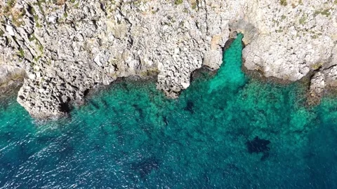 Aerial view of rocky coastline cliffs with turquoise sea waves Stock Footage 345150776