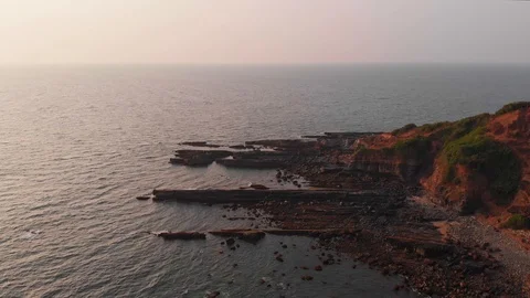 Aerial view of a rocky seashore during sunset Stock Footage 126861455