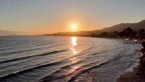 Aerial view of Roda beach sunset with gentle waves, golden reflection on sea Stock Footage 346745399