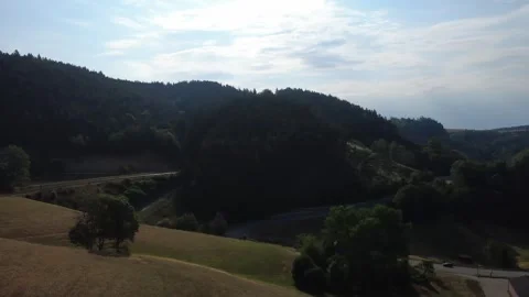 Aerial view of rolling green hills and countryside on a sunny summer day Stock Footage 340520698