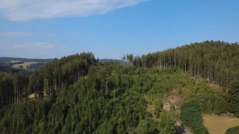 Aerial view of rolling green hills and countryside on a sunny summer day Stock Footage 340520868