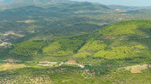 Aerial view of the rolling green hills and dense forests of the Toroni area in Stock Footage 346709353
