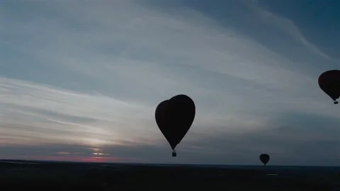 Aerial view romantic balloon flight in the form of a large red heart at sunset. Stock Footage 137975366