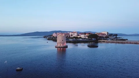 Aerial view of a romantic windmill on a calm sea lagoon at dusk, with seagulls Stock Footage 107848116