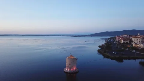 Aerial view of a romantic windmill on a calm sea lagoon at dusk, with seagulls Stock Footage 107848166