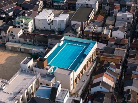 Aerial view of rooftop pool in compact Osaka neighborhood at dusk Foto stock