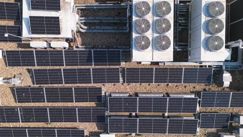 Aerial view of rooftop solar panels and industrial HVAC systems on a flat Stock Footage 310729170