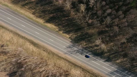 Aerial view of rotating drone over a straight asphalt road with markings Stock Footage 153521327