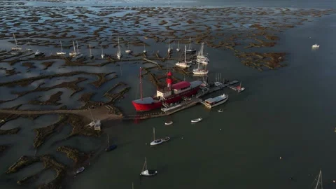 Aerial view rotating pan of large ship at Tollesbury Marsh at high tide Stock Footage 234512817