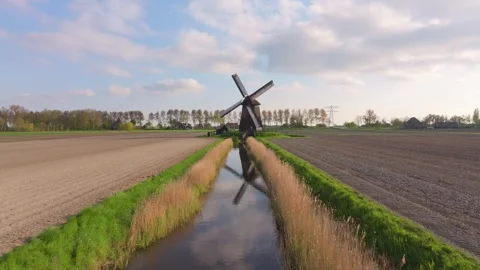 Aerial view of rotating windmill with canals and fields in Netherlands Stock Footage 313364542