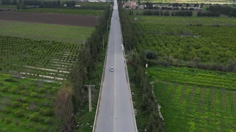 Aerial view of a roundabout and long straight road through agricultural farmland Stock Footage 336484064