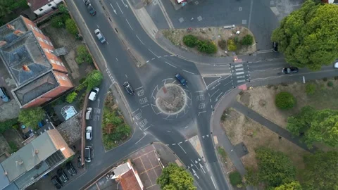 Aerial view of a roundabout and surrounding roads with cars, houses, and tree Stock Footage 340519101