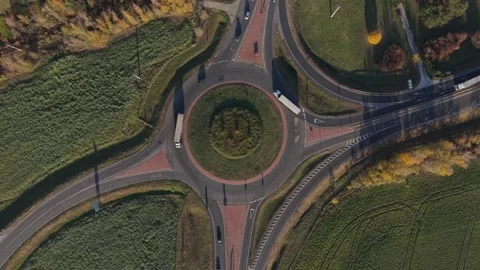 Aerial view of a roundabout surrounded by green fields and intersecting roads Stock Footage 320431196