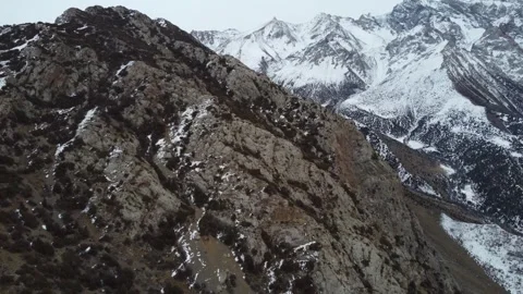 Aerial View of Rugged Alpine Cliffs and Snowy Peaks Video stock 331654204