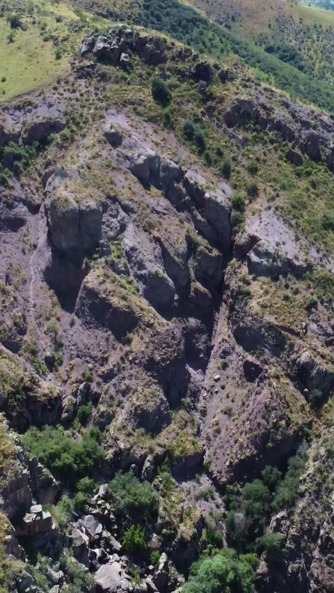 Aerial view of rugged basalt mountainside and eroded red canyon in Kazakhstan Stock Footage 338127735