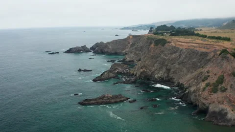 Aerial view of rugged cliffs and colorful ocean in Pacific Coast of California Stock Footage 200775322