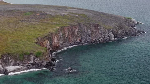 Aerial view of rugged cliffs and cove on the rocky headland of Lavrentiya Bay Stock Footage 327121056